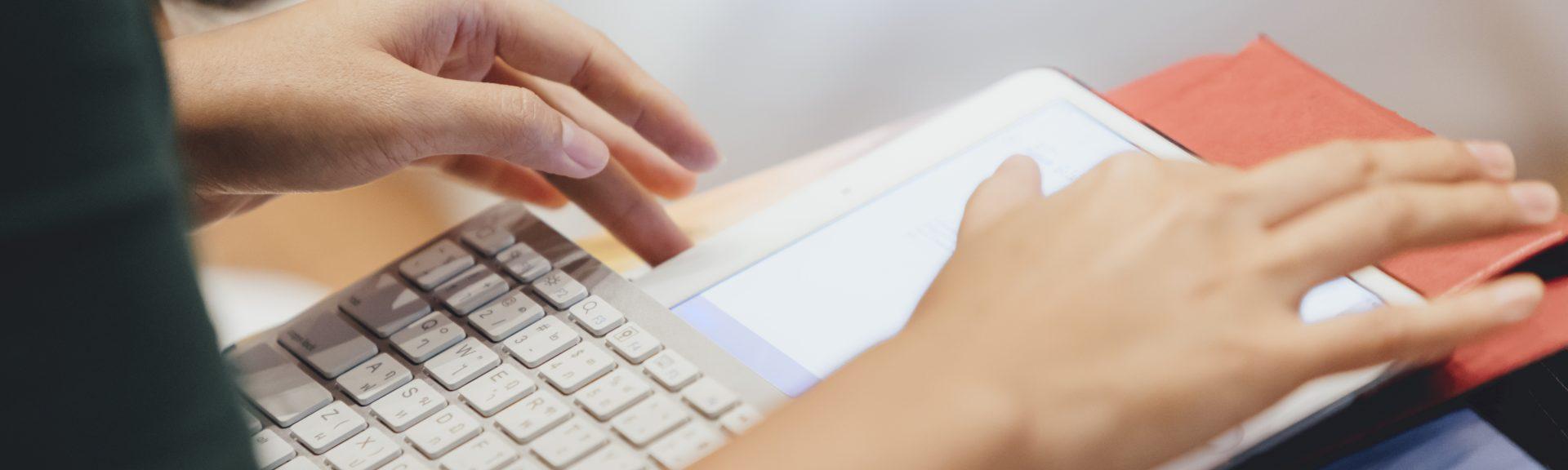 Woman works on her tablett with a keyboard attached