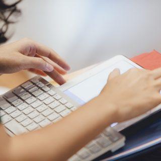 Woman works on her tablett with a keyboard attached