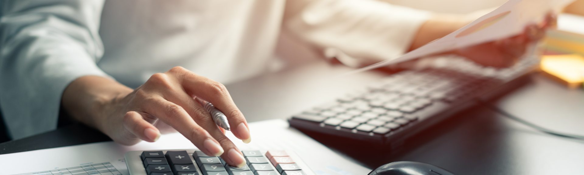 Woman accountant or banker use calculator and pen, computer, graph paper on table at office. Business and finances Saving Economy concept.