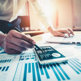 Businessman accountant or financial expert analyze business report graph and finance chart at corporate office. Concept of finance economy, banking business and stock market research.