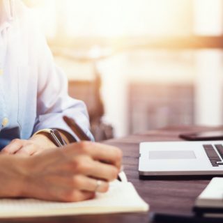 Young beautiful woman working with a laptop. Female freelancer connecting to internet via computer. Blogger or journalist writing new article.