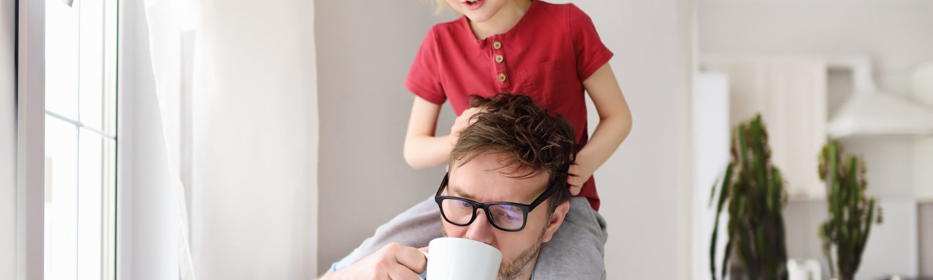 Man working from home with laptop during quarantine. Home office and parenthood at same time. Exhausted parent with hyperactive child. Chaos with kids during isolation