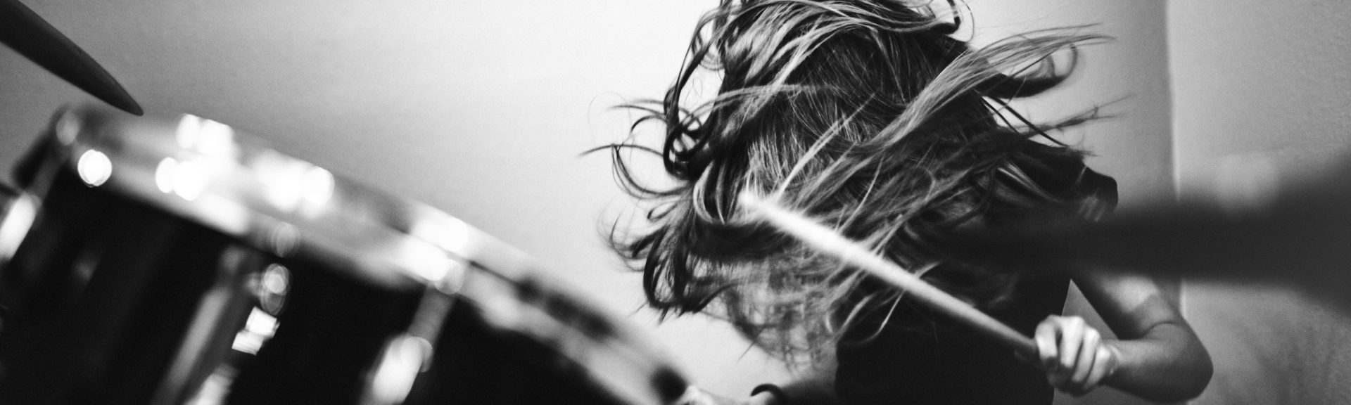 Girl Playing Rock and Roll Drums. head banging. Black and white