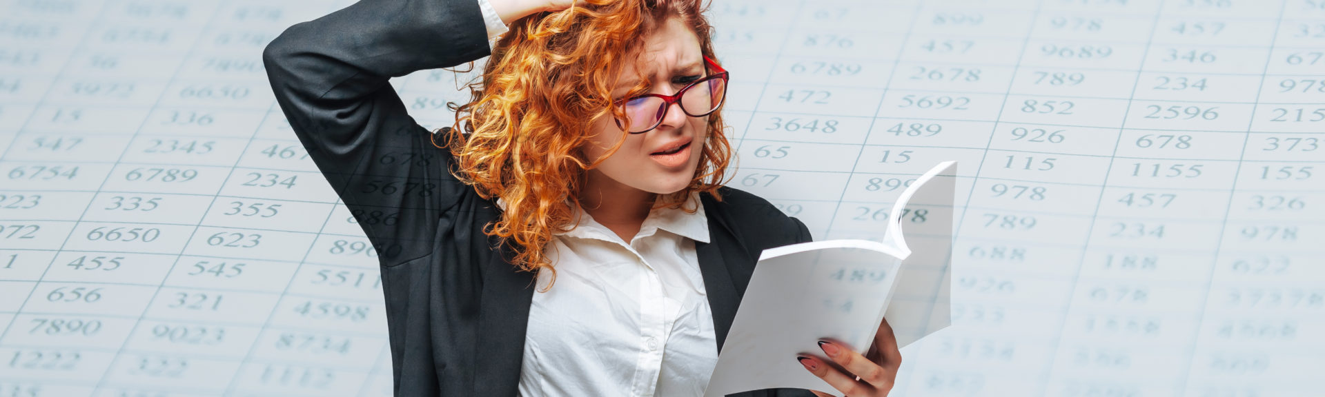Eine Dame mit Brille hält ein Buch oder Skript, greift sich in die Haare und liest vertieft