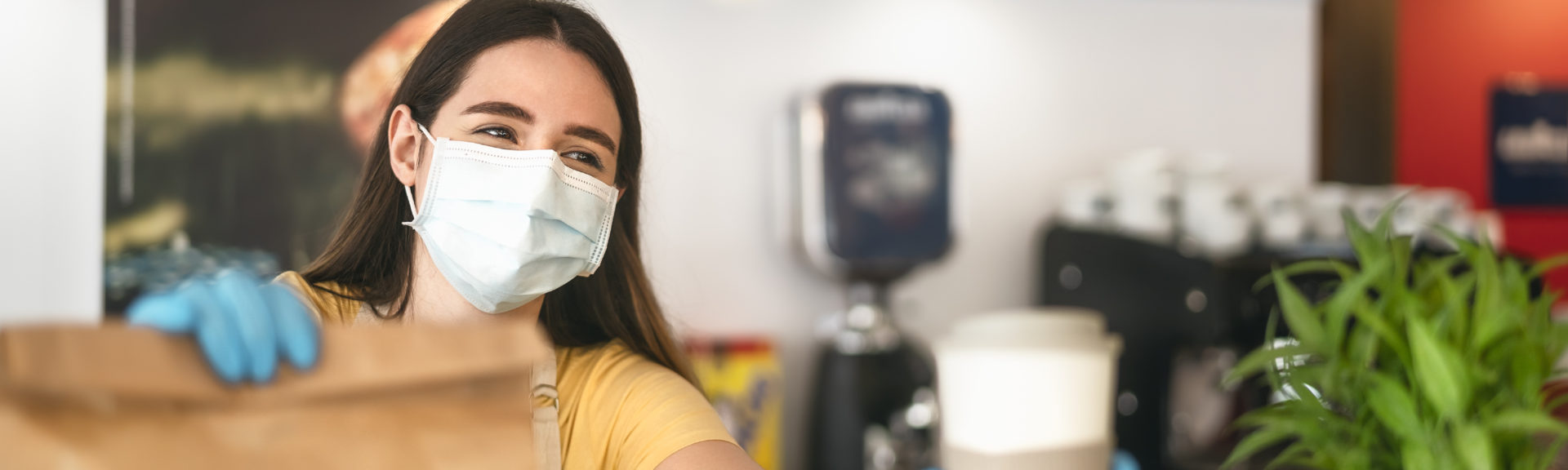 Bar owner working only with take away orders during corona virus outbreak - Young woman worker wearing face surgical mask giving meal to customers - Healthcare and Food drink concept