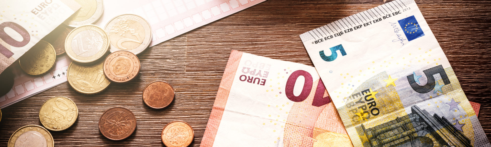 Euro banknotes and coins with bills to pay. Finances and budget concept