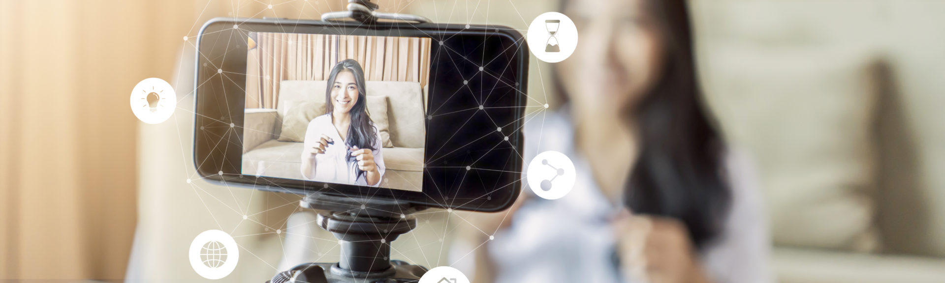 Asian businesswoman working from home live video interaction with customers using camera device vlogging selling make up products, viral internet social media influencer interacting to live audience