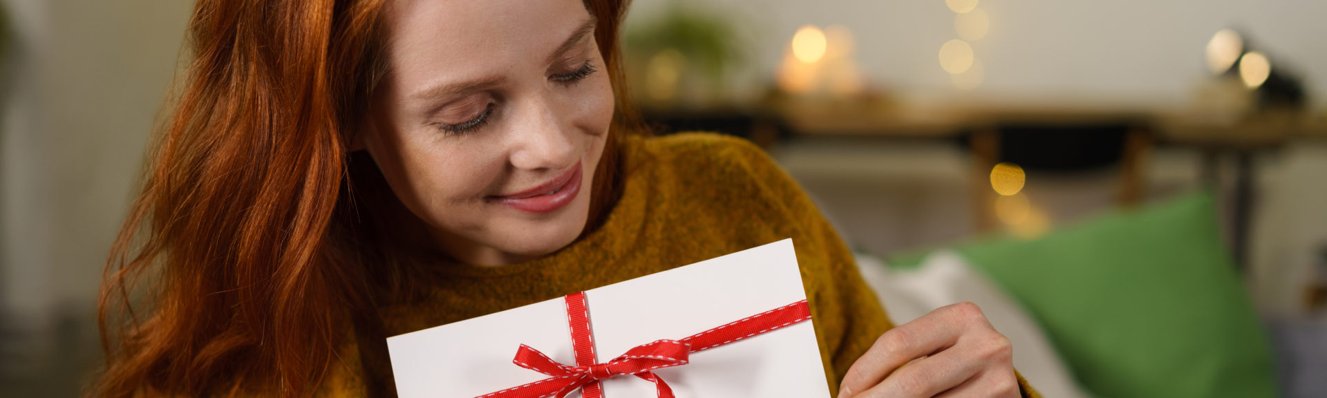 frau freut sich über einen gutschein zu weihnachten
