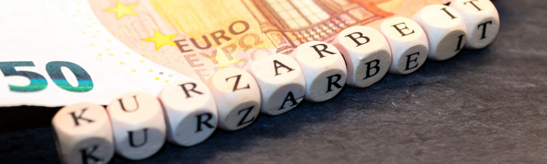 Kurzarbeit mit Geldschein im Hintergrund