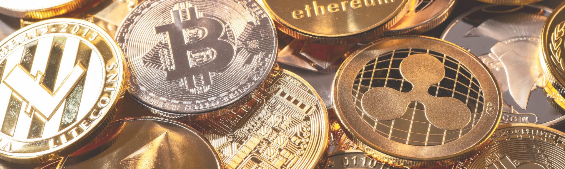 Verschiedene Kryptowährungen liegend verstreut übereinander