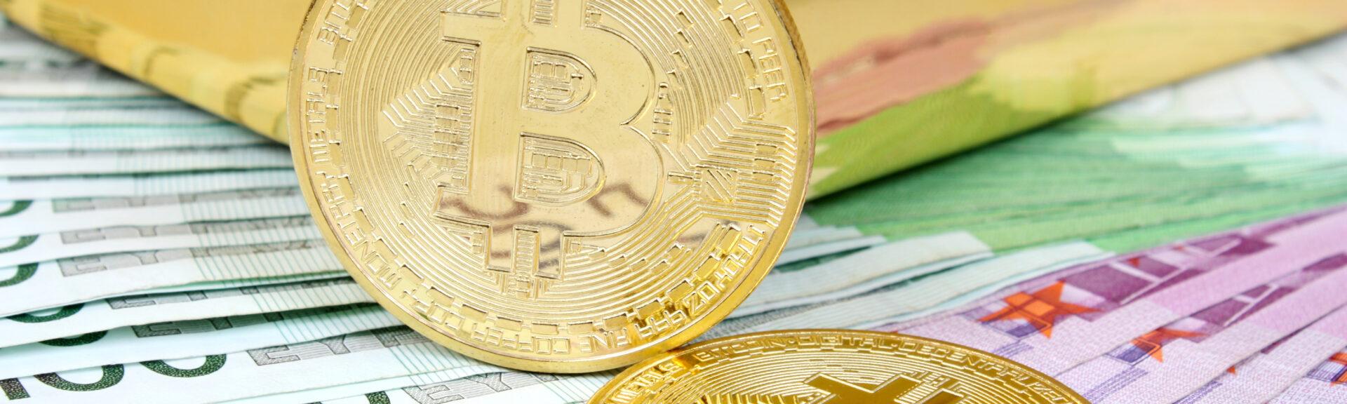 Bitcoin, Kryptowährung mit Goldbarren im Hintergrund auf Gelscheinen