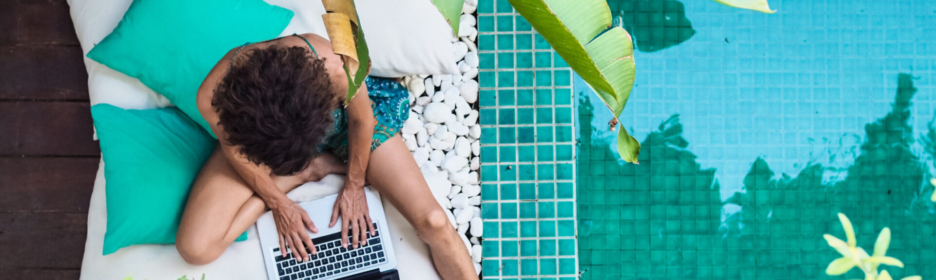 Homeoffice am Pool. Woman sitting on pillows