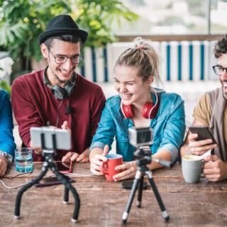 Young friends group sharing info on streaming platform with webcam - Startup marketing concept with millennial guys and girls having fun vlogging live talk feed on social media network - Bright filter