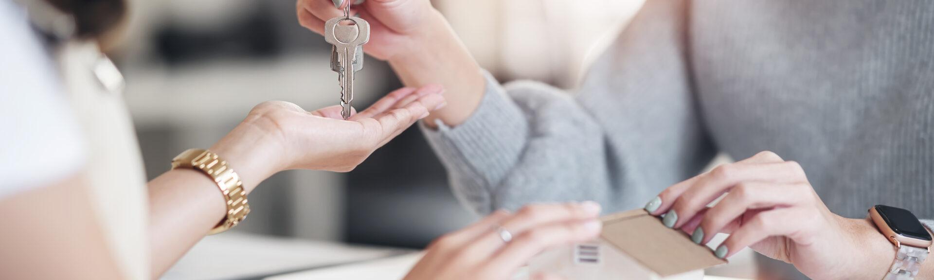 Buying real estate and agreement concept. Real estate agents agree to buy a home and give keys to clients at their agency's offices.