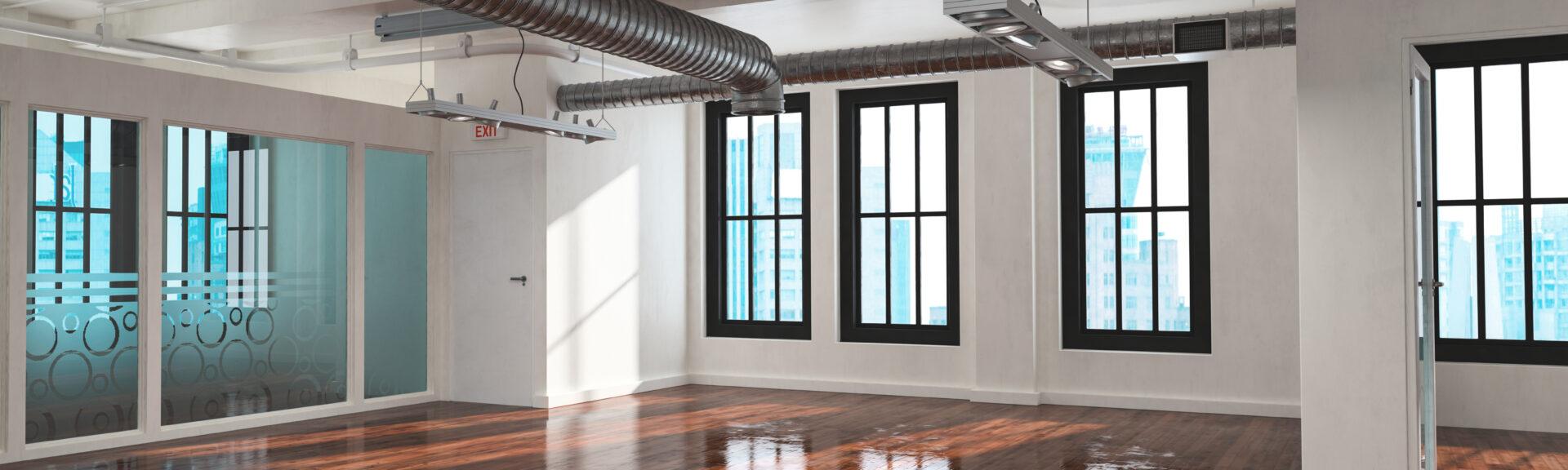 Trendy empty bare open plan industrial loft conversion with multiple windows, exposed metallic pipe ducts and a reflective highly polished wood floor. 3d rendering