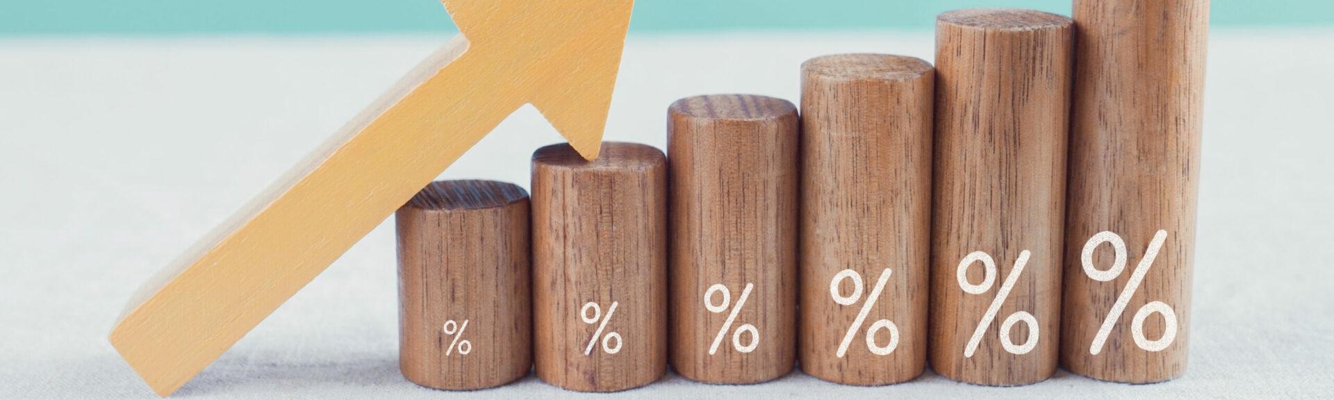 Wooden blocks with percentage sign and arrow up, financial growth