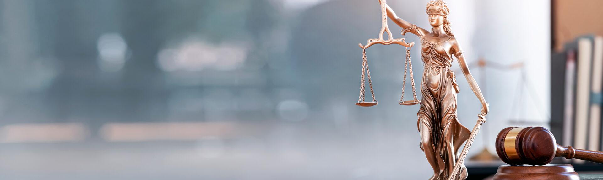 Legal and law concept. Statue of Lady Justice with scales of justice and wooden judge gavel on wooden table. Panoramic image statue of lady justice.
