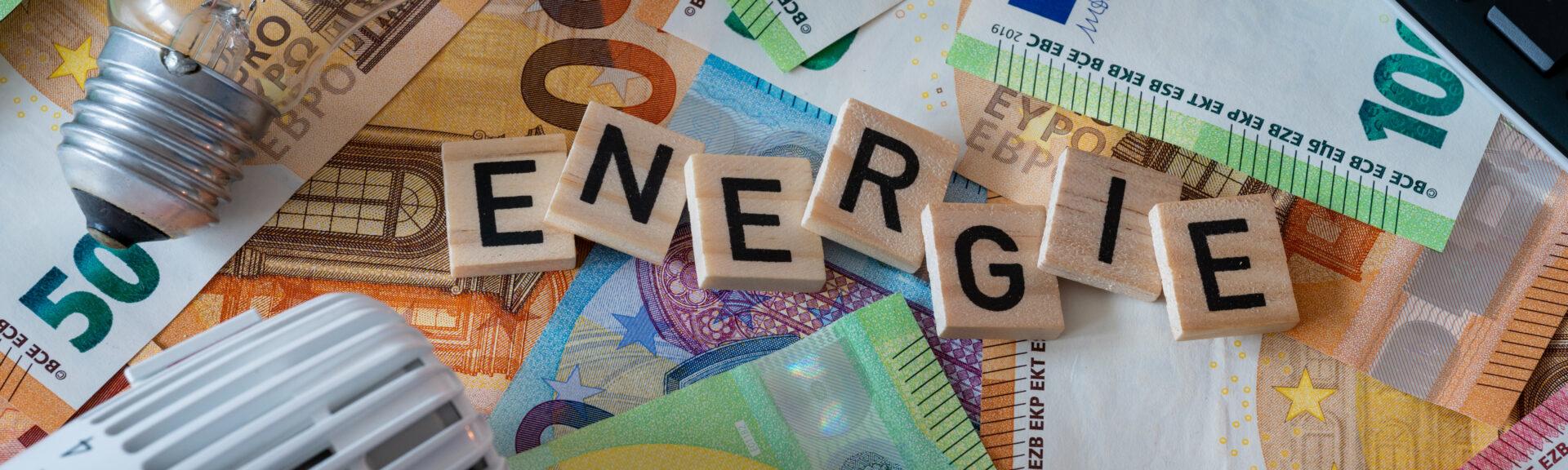 Text auf Hintergrund mit Banknoten zum Thema Energiekosten