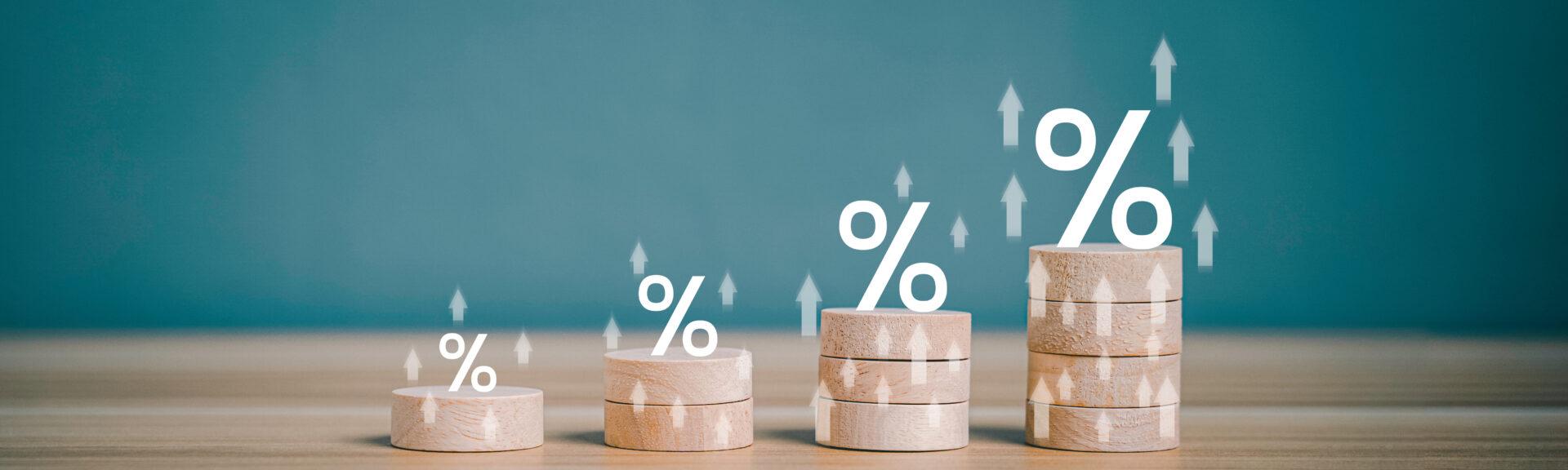 Interest rate financial and mortgage rates concept. Wooden block increasing on top with percentage symbol and arrow upward direction. Return on stocks and mutual funds from business growth concept.