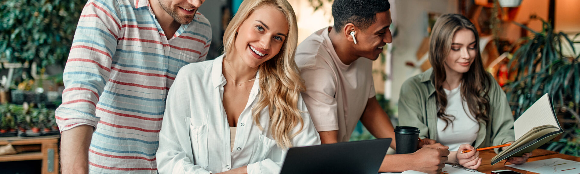 Multiracial creative people in modern office. Group of young business people and senior boss are working together with laptop, tablet, smart phone, notebook, graphs. Successful team in coworking