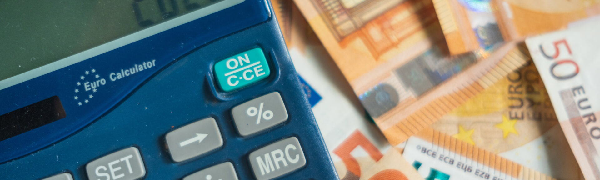 2025 calculator with 50 euro notes bills on background