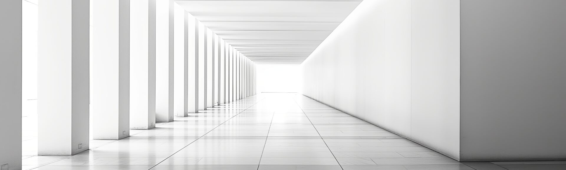 The photo captures the essence of minimalist architecture, featuring an impeccably symmetrical white corridor leading into infinity
