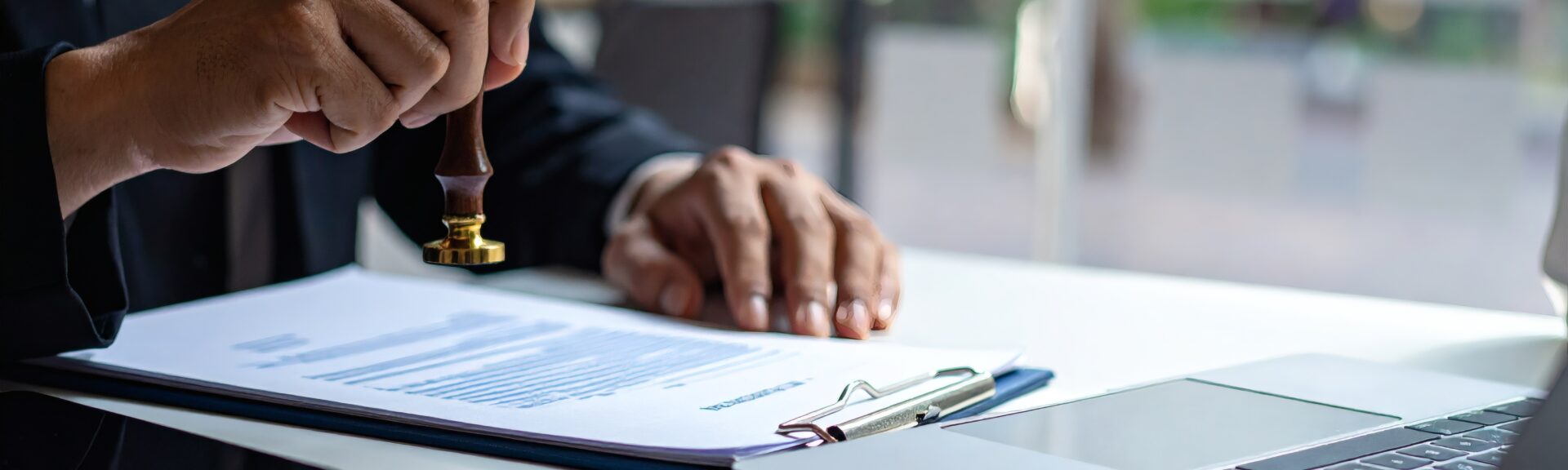 Man stamping approval on financial, banking, or investment documents at his desk official paperwork. rubber stamp with contract law and business documentation for legal agreements financial