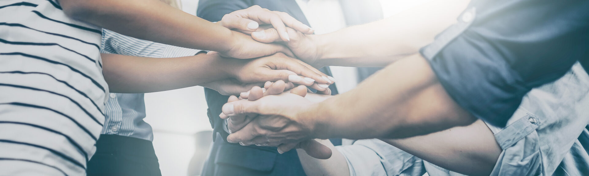 Close up view of young business people putting their hands together. Stack of hands. Unity and teamwork concept.