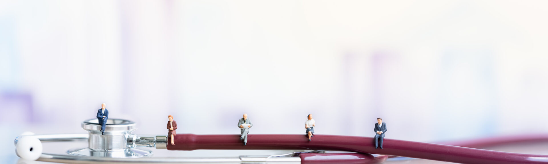 Miniature people: Elderly people sitting on Stethoscope. social security income and pensions. Health Care Inequality. Time counting down for retirement concept. Social distancing.