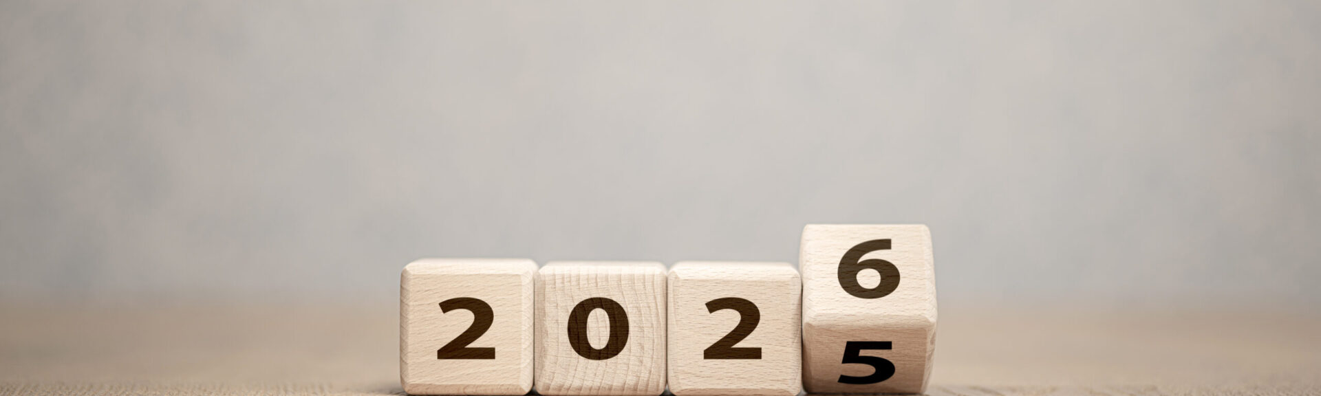 Wooden cubes changing year 2025 to 2026 on neutral background